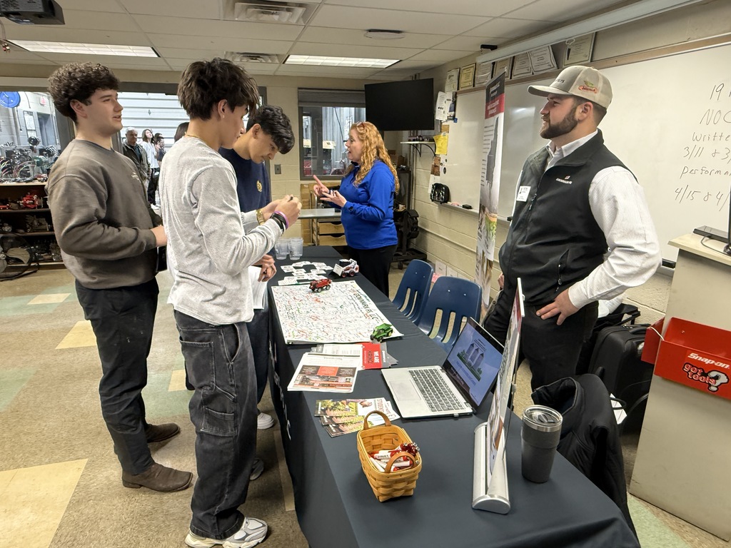 Students gather at an industry information table inside a BCTC classroom while representatives discuss career pathways and hands-on opportunities during Construction and Transportation Career Day.