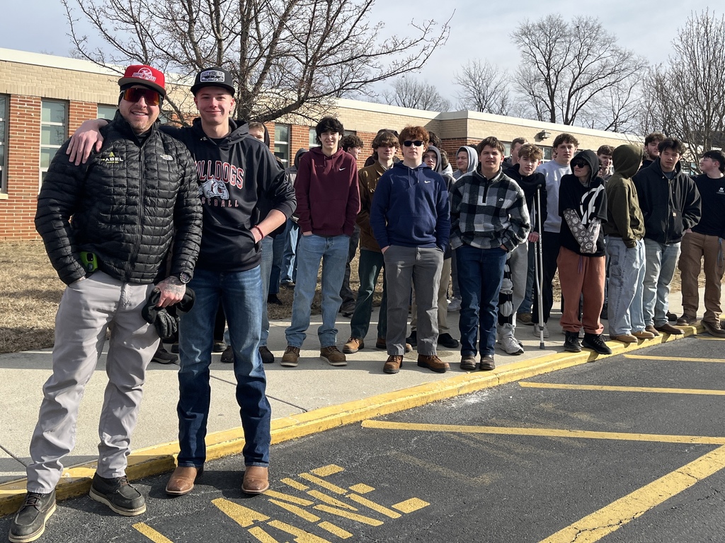 Electrical Occupations students stand outdoors with an I.B. Abel representative on campus.