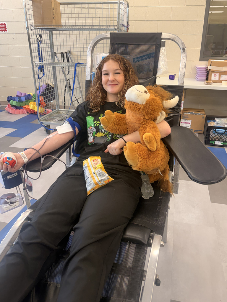 Student donor sits comfortably in a blood donation chair holding a plush toy while donating blood during the BCTC blood drive.