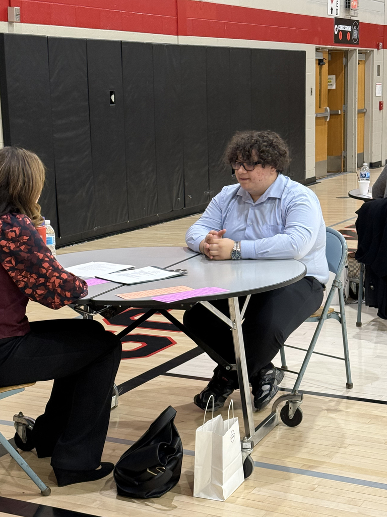 Service Occupations student sits across from a professional interviewer during a mock interview session at an Employability Expo.
