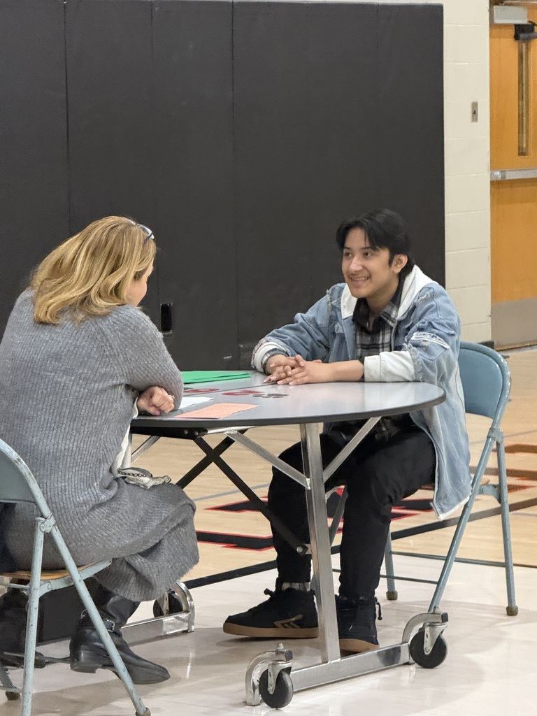 Service Occupations student speaks with a professional interviewer at a round table during an Employability Expo mock interview session.