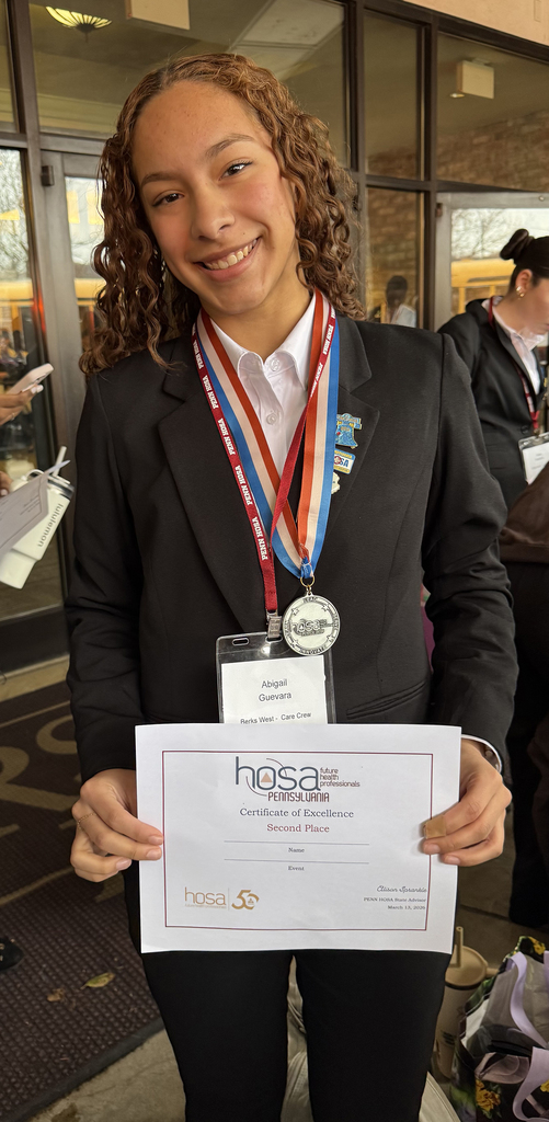 Student wearing a medal and conference badge holds a Penn HOSA certificate of excellence after placing second at the state conference.
