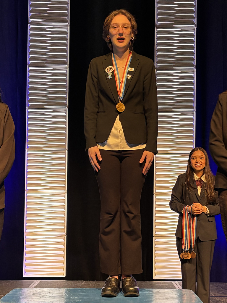 Student in professional HOSA attire stands on an awards podium wearing a medal during the Penn HOSA State Leadership Conference.