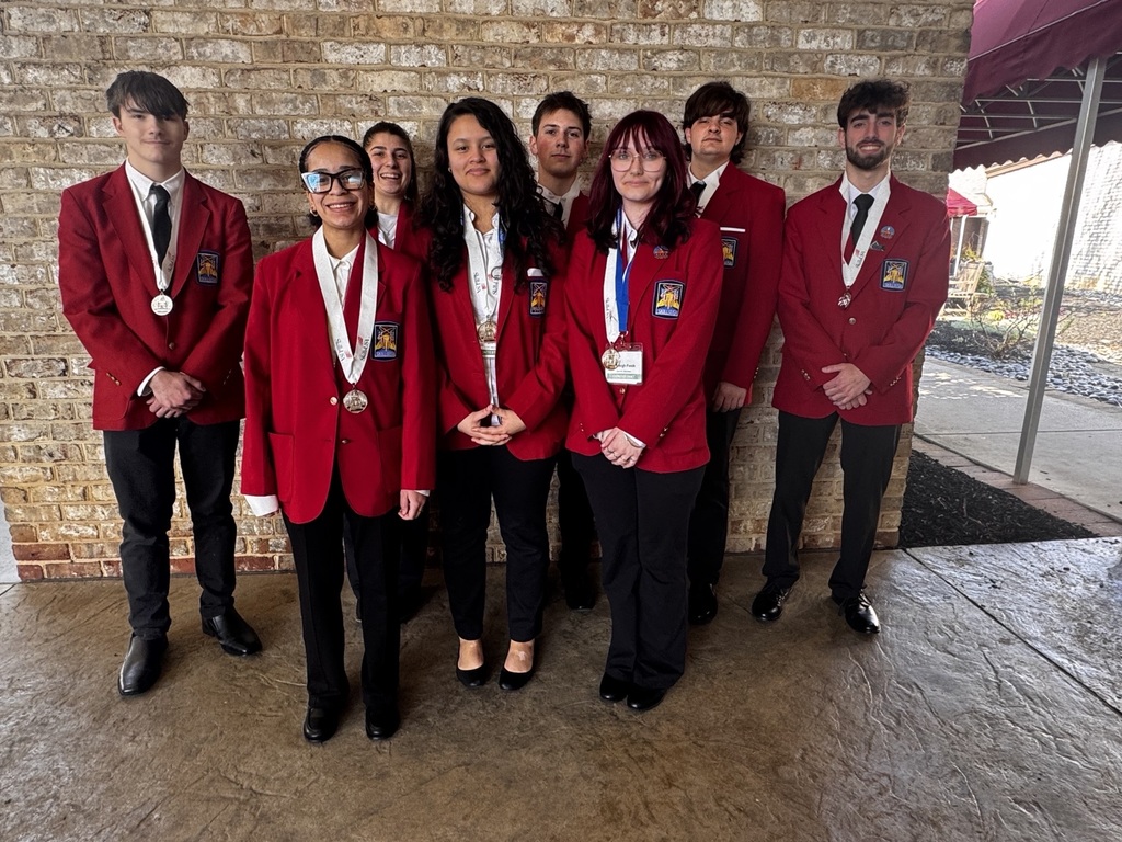 A group of BCTC students in red SkillsUSA blazers stand together outside after the conference, several wearing medals and smiling for a group photo.