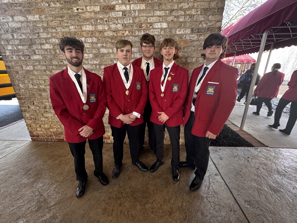 Five BCTC students in red SkillsUSA blazers stand together outside wearing medals and smiling after the conference.