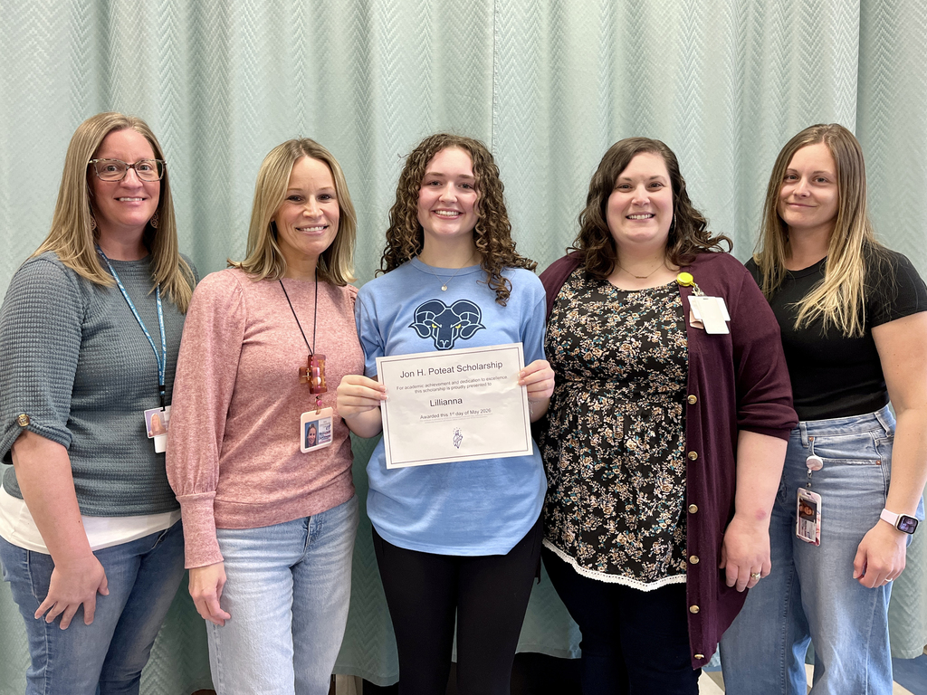Lillianna stands with Health Occupations staff members while holding her Jon H. Poteat Scholarship certificate.