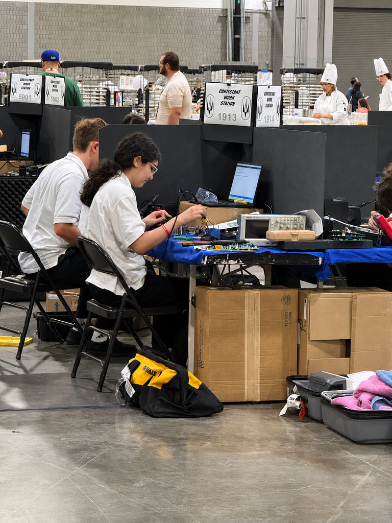 Two SkillsUSA competitors work at an electronics station during national competition.