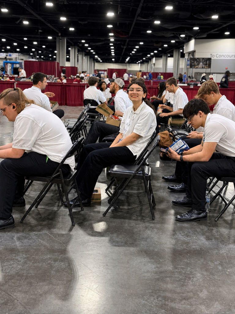 SkillsUSA competitors sit between events inside the national conference venue.