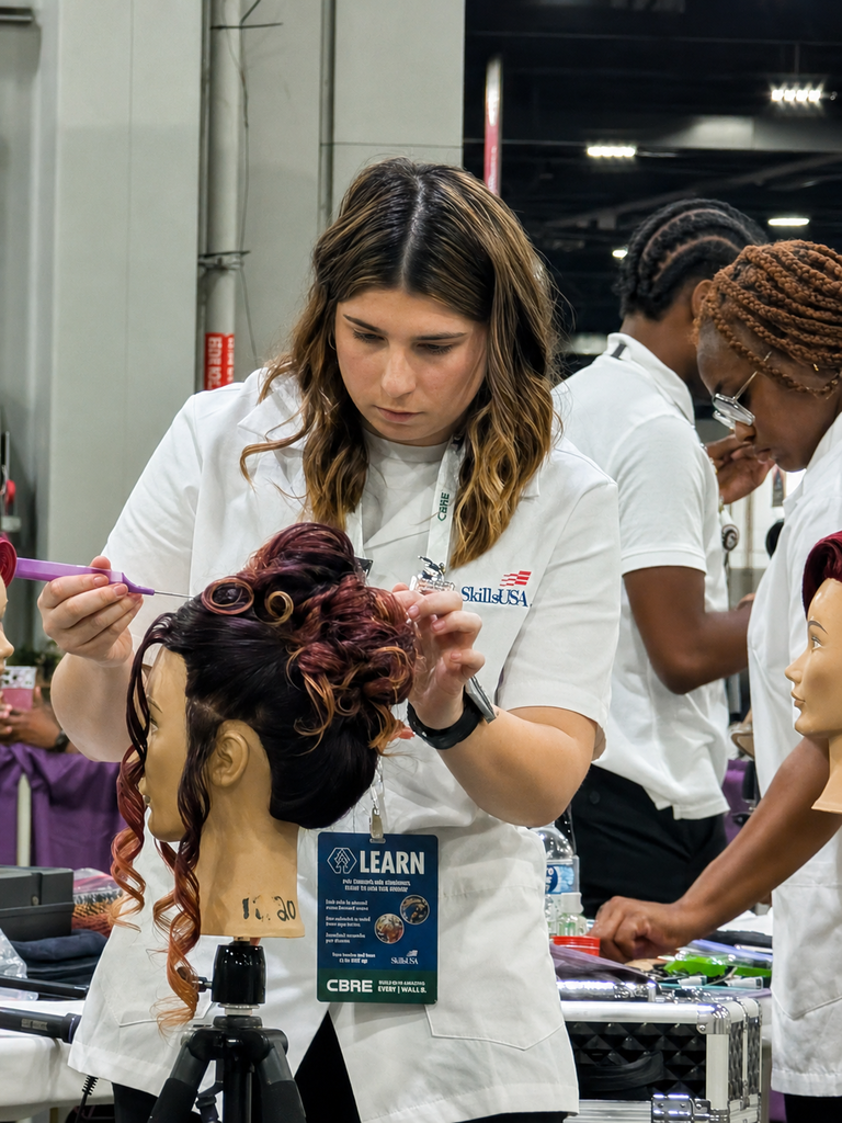 A BCTC SkillsUSA competitor styles a mannequin head during cosmetology competition.