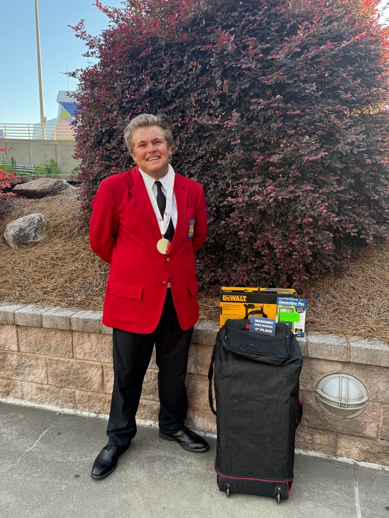 Owen, a BCTC Masonry alumnus, smiles while wearing his SkillsUSA gold medal beside his 1st place award and tools.