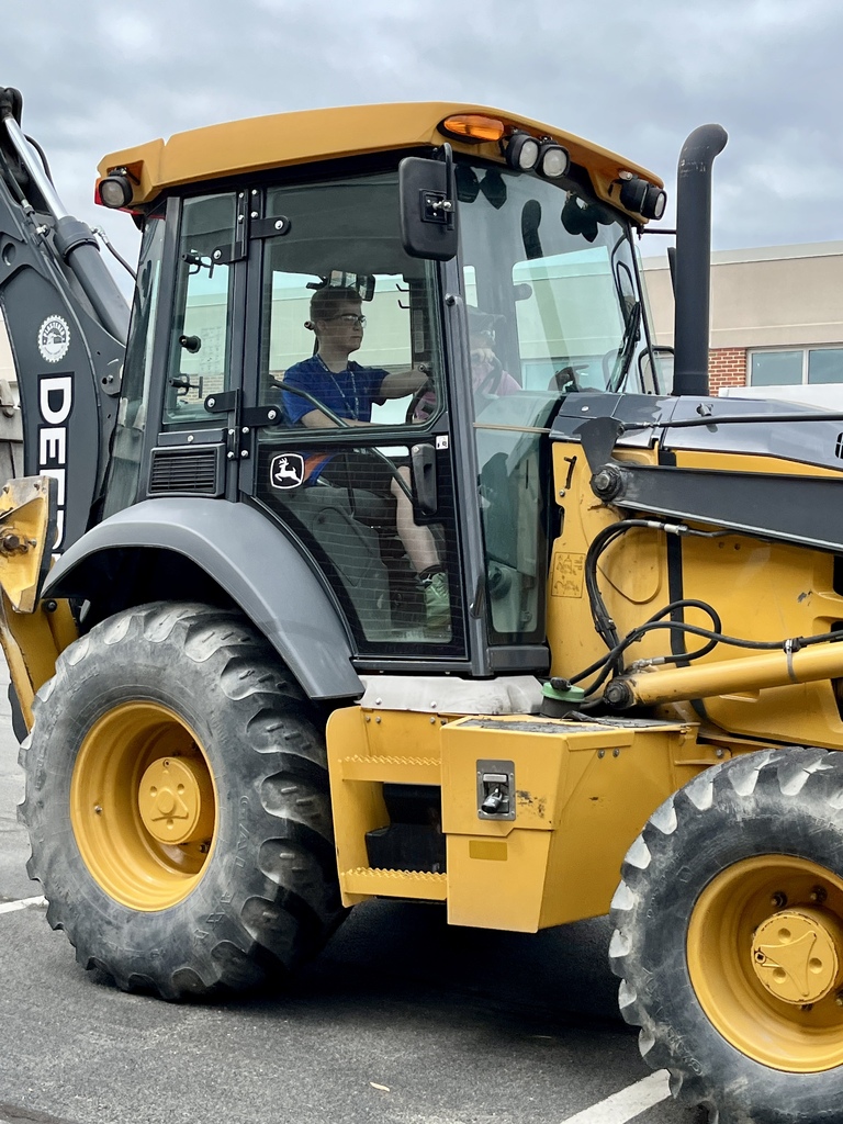 A Career Camp participant sits inside the cab of a backhoe during a hands-on equipment activity.