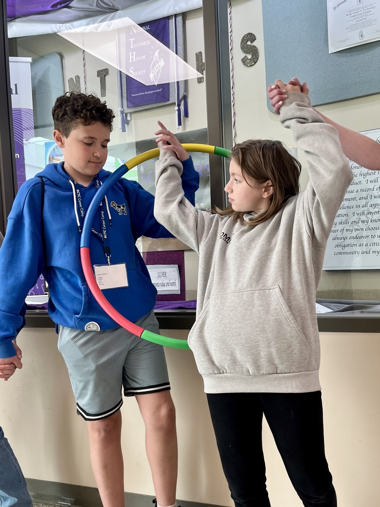Two Career Camp participants pass a hula hoop between them while holding hands during a teamwork challenge.