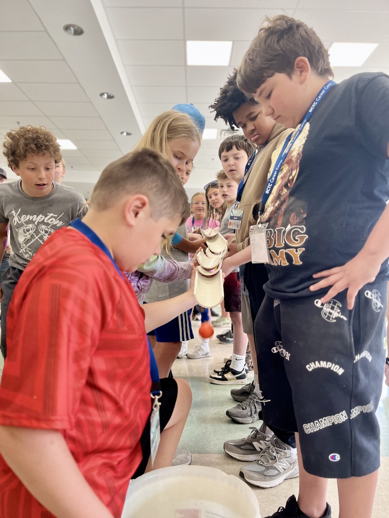 Career Camp participants work together to guide an orange ball through connected pipe pieces during a team-building activity.