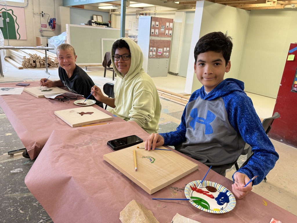 Career Camp participants paint designs on wooden boards during a hands-on workshop activity.