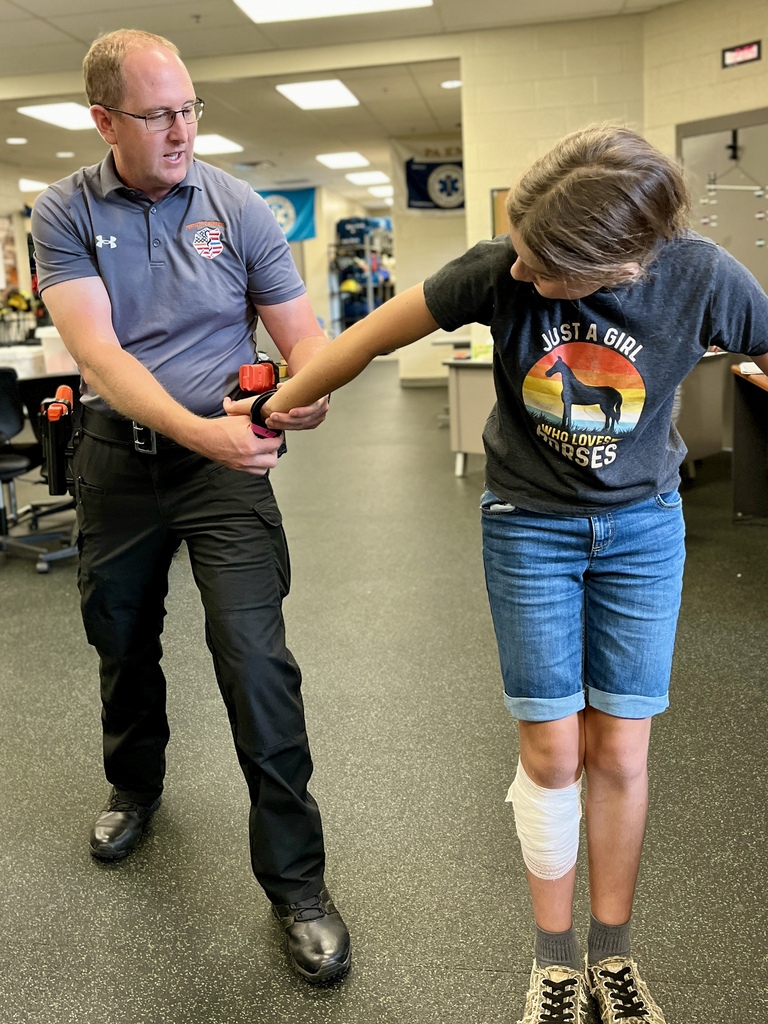 Protective Services instructor demonstrates a control hold with a Career Camp participant.