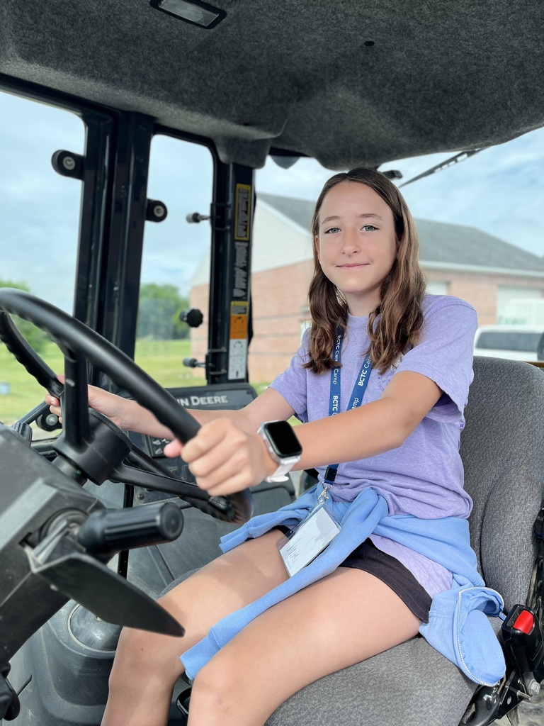 Career Camp participant sits in the operator seat of a John Deere machine.