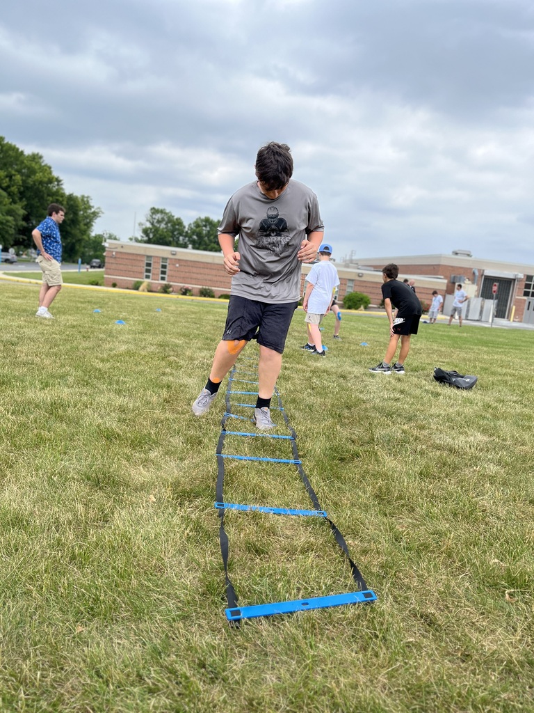 Career Camp participant moves through an agility ladder during an outdoor fitness activity.