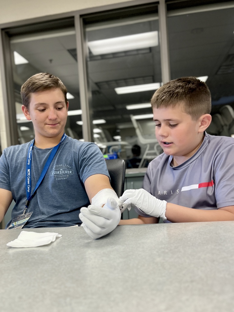Career Camp participants practice gloved wound care skills on a classmate’s arm.