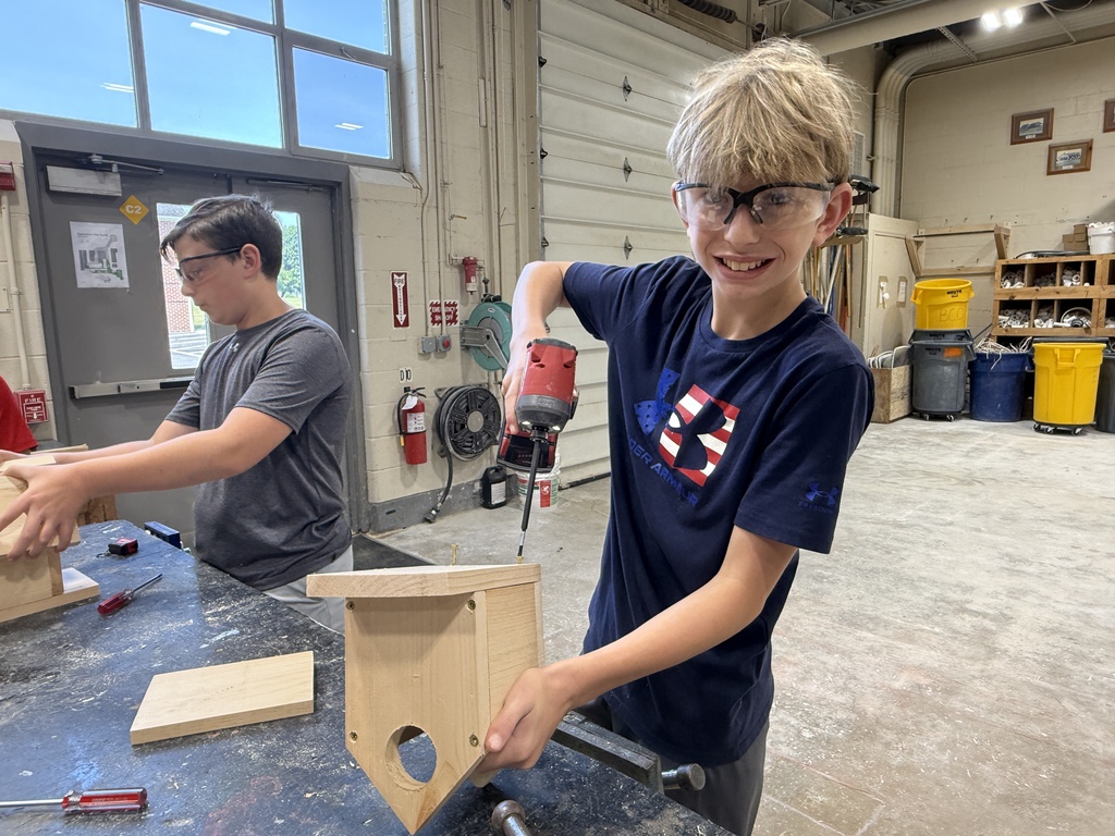 Career Camp participant uses a drill while assembling a wooden birdhouse project in a BCTC lab.