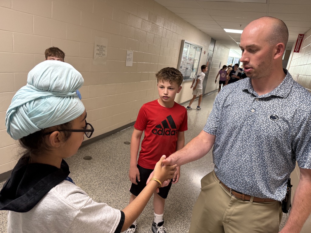 Career Camp participants shake hands with a staff member during a campus scavenger hunt challenge.