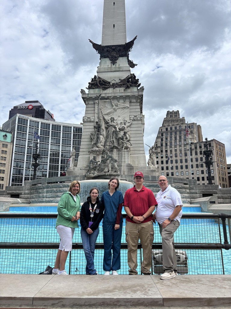 BCTC HOSA students and advisors stand in front of a large monument and fountain in downtown Indianapolis.