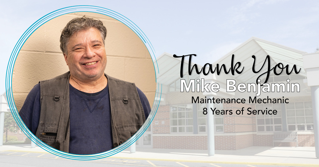 A man in a blue shirt and brown vest smiles at the camera. Text reads "Thank You Mike Benjamin".