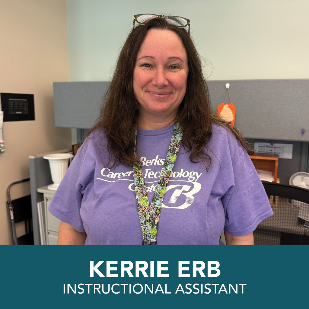 Woman in a purple shirt, smiling and standing in an office. Text at bottom reads "KERRIE ERB, INSTRUCTIONAL ASSISTANT".