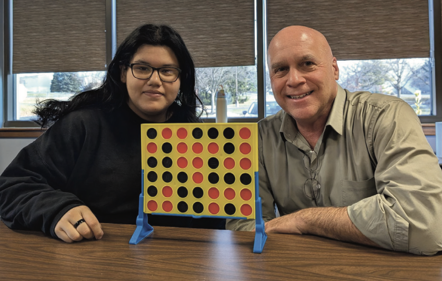 student and program administrator playing connect 4