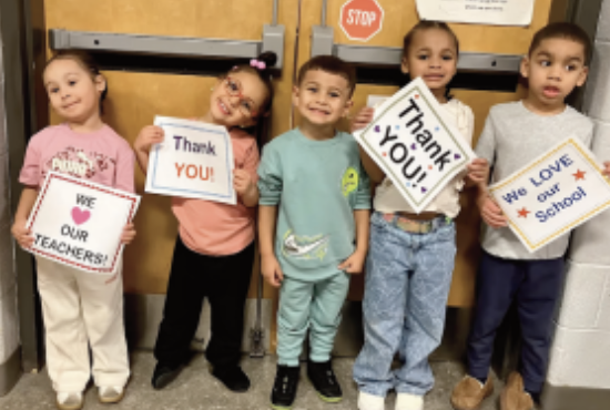 children holding thank you signs for staff