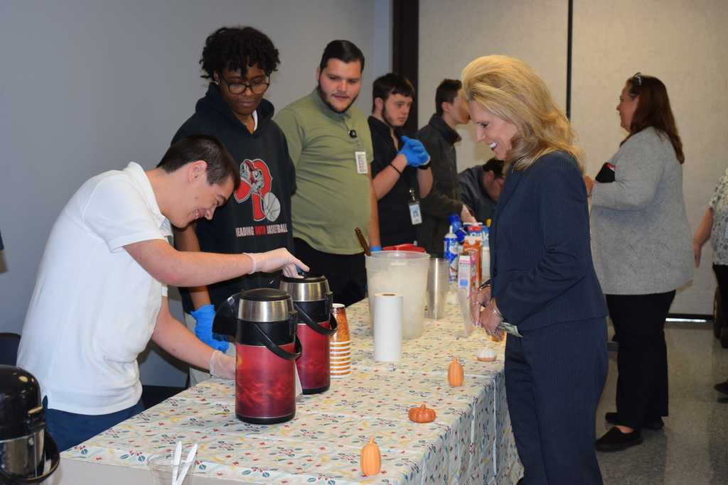 student pouring coffee for dr. hackman