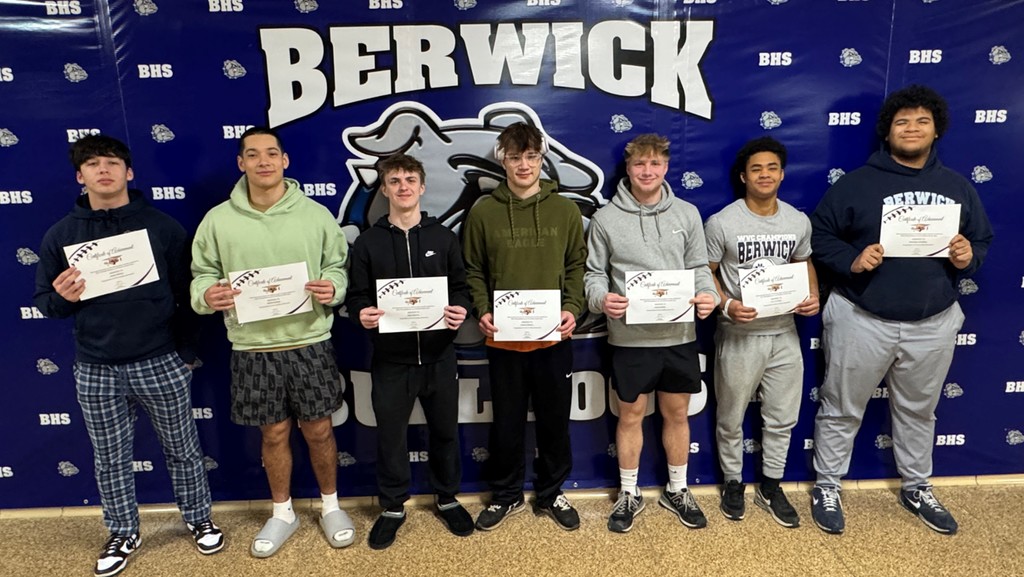football players standing in a group with certificates