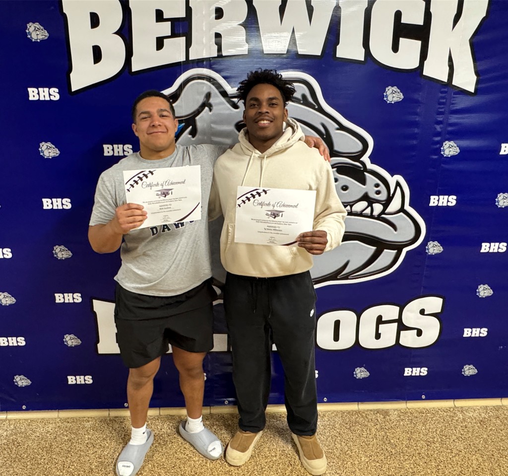 football players standing together with certificates