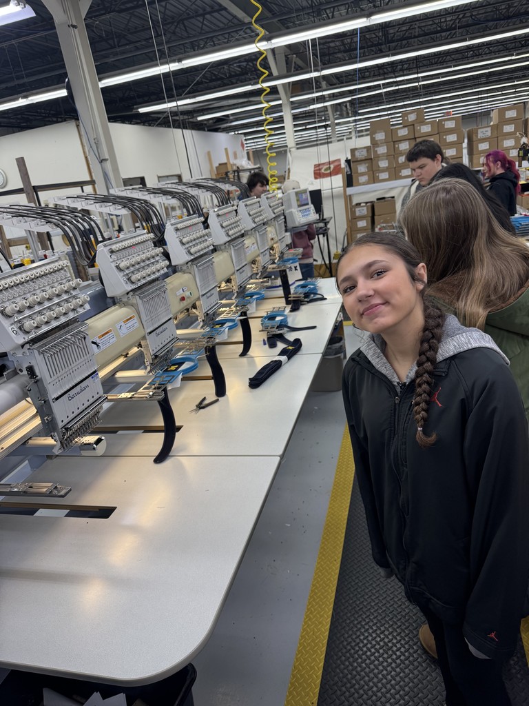Student next to industrial sewing machines
