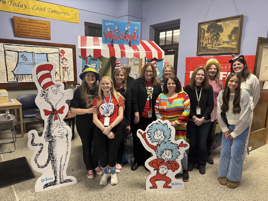School staff dressed for Dr. Seuss Night standing with Cat in the Hat characters