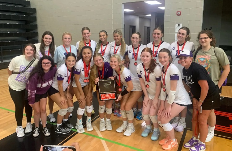 volleyball team posing with a tournament trophy