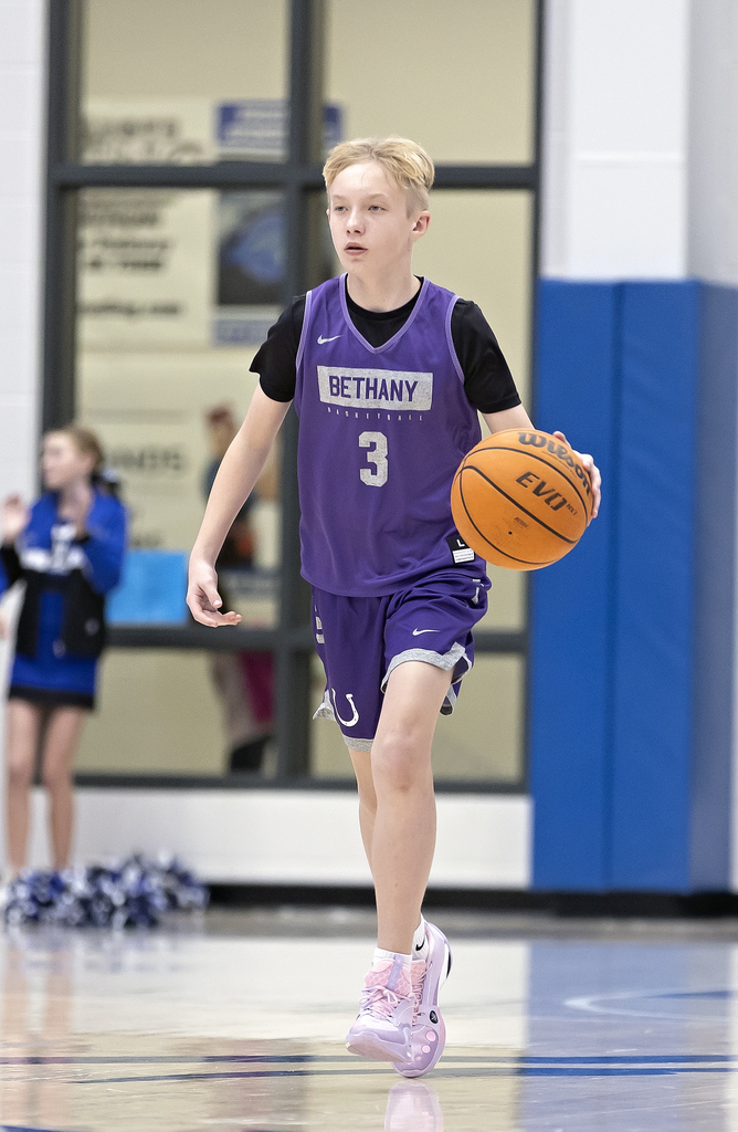 picture of an 8th grade basketball player dribbling up the court