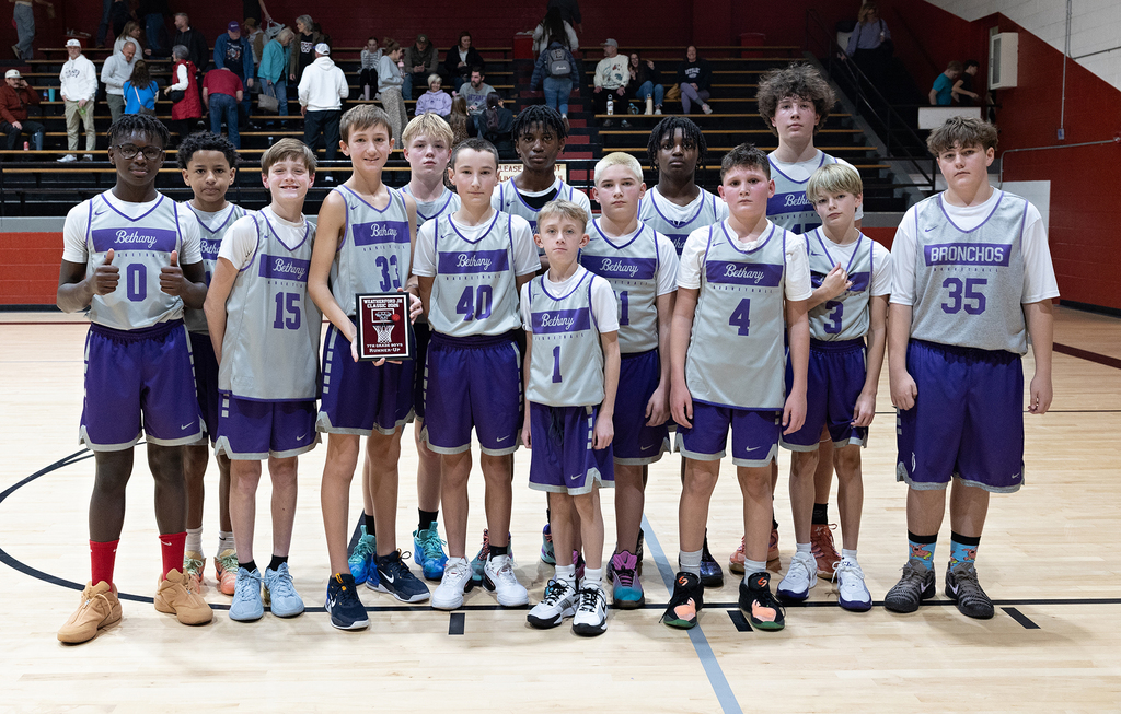picture of 7th grade boys team on the basketball court holding the second place plaque