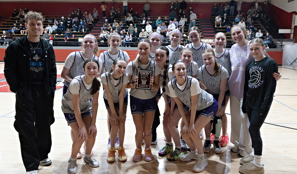 picture of 7th grade girls basektball team on the court holding the second place plaque