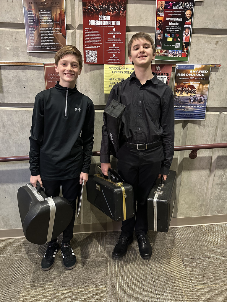 two male students in black ensemble attire posing with instrument cases
