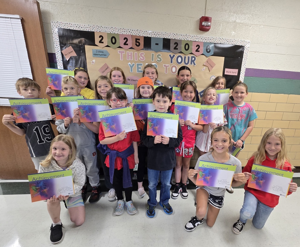 Students of the month pictured smiling and holding Achievement certificates