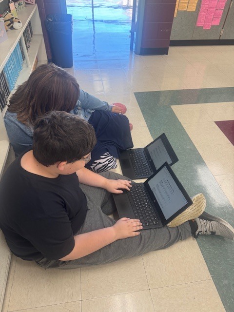 Students in Mrs. Starline’s language arts class took part in a fun writing challenge. Using illustrations displayed on the screen for inspiration, they wrote creative sentences and then combined their ideas to form a silly story, which they shared with a partner.