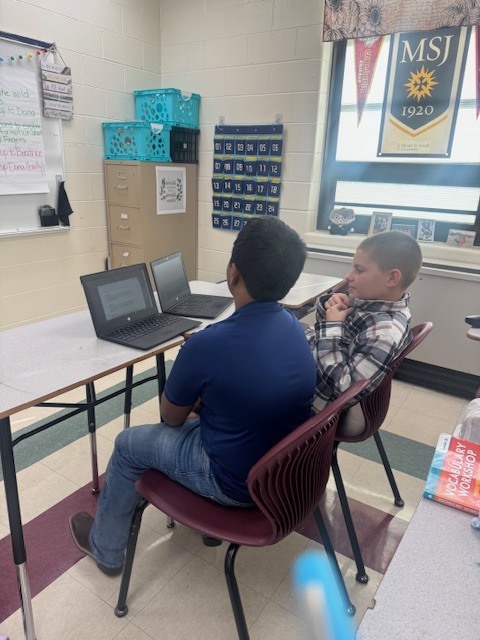 Students in Mrs. Starline’s language arts class took part in a fun writing challenge. Using illustrations displayed on the screen for inspiration, they wrote creative sentences and then combined their ideas to form a silly story, which they shared with a partner.