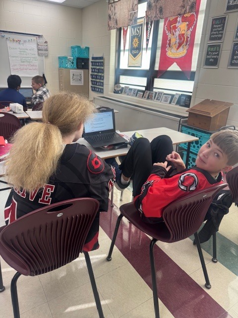 Students in Mrs. Starline’s language arts class took part in a fun writing challenge. Using illustrations displayed on the screen for inspiration, they wrote creative sentences and then combined their ideas to form a silly story, which they shared with a partner.