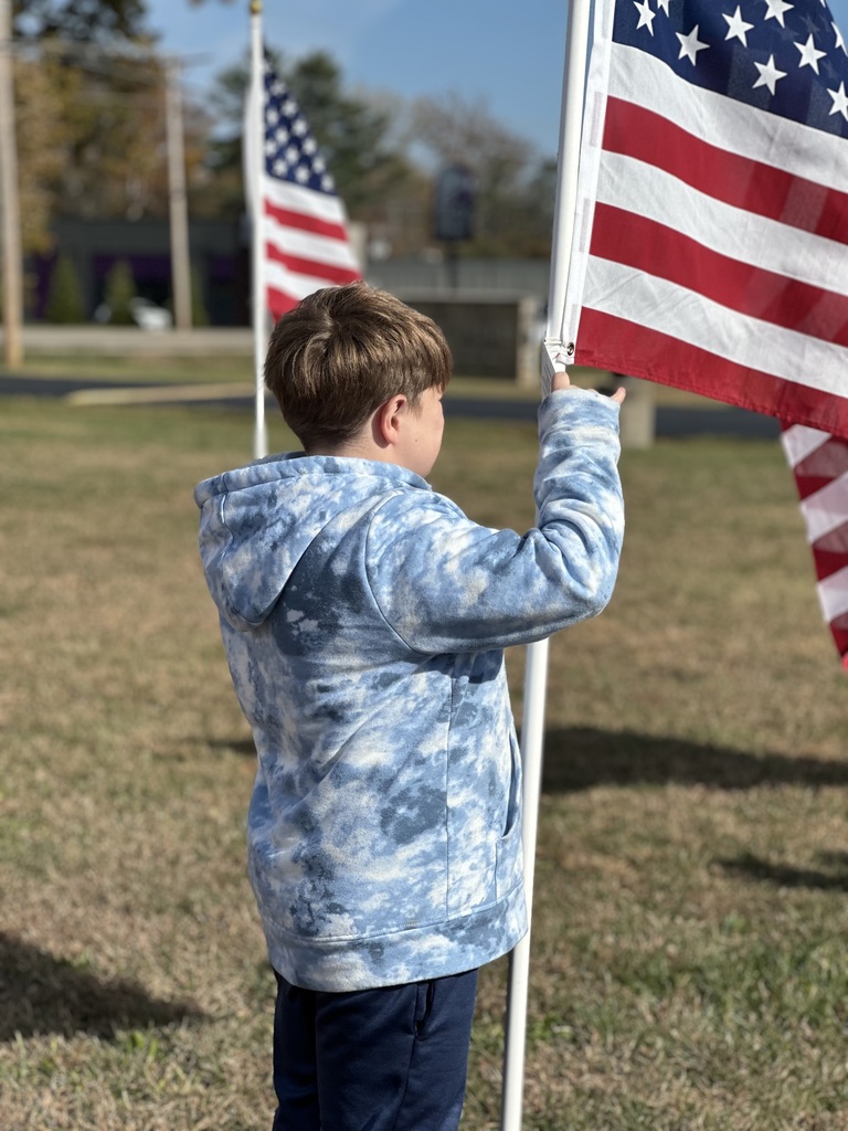Students read the names through the flag field and honor our Veterans.