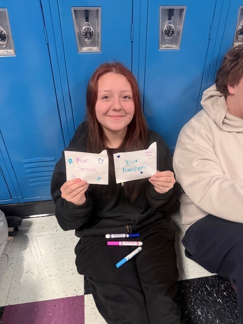 A student holding kindness cards she made 