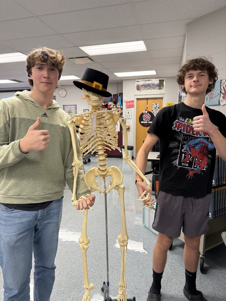 students standing with a human skeletan wearing  hat