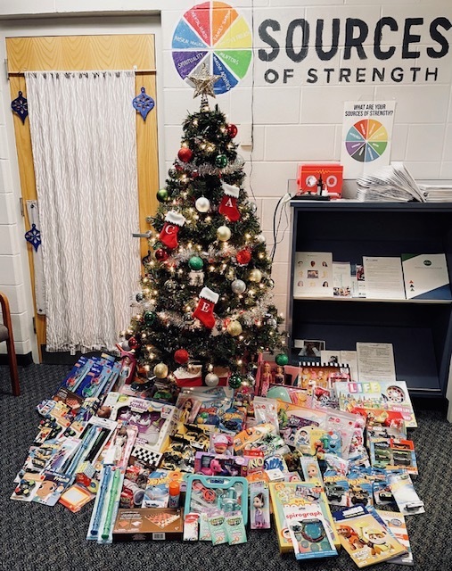 Tree with collected toys displayed beneath as part of a toy drive