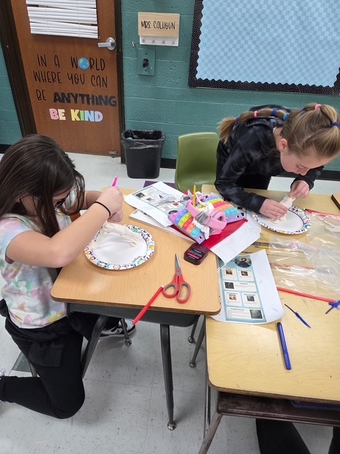 2 students working on their science art project