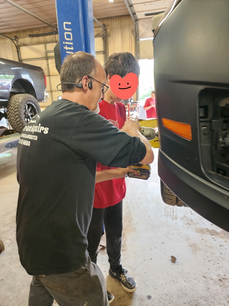 Students learning about working on car for work experience
