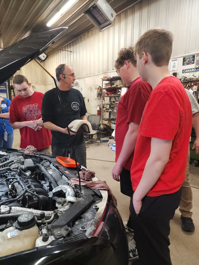 Students learning about working on car for work experience